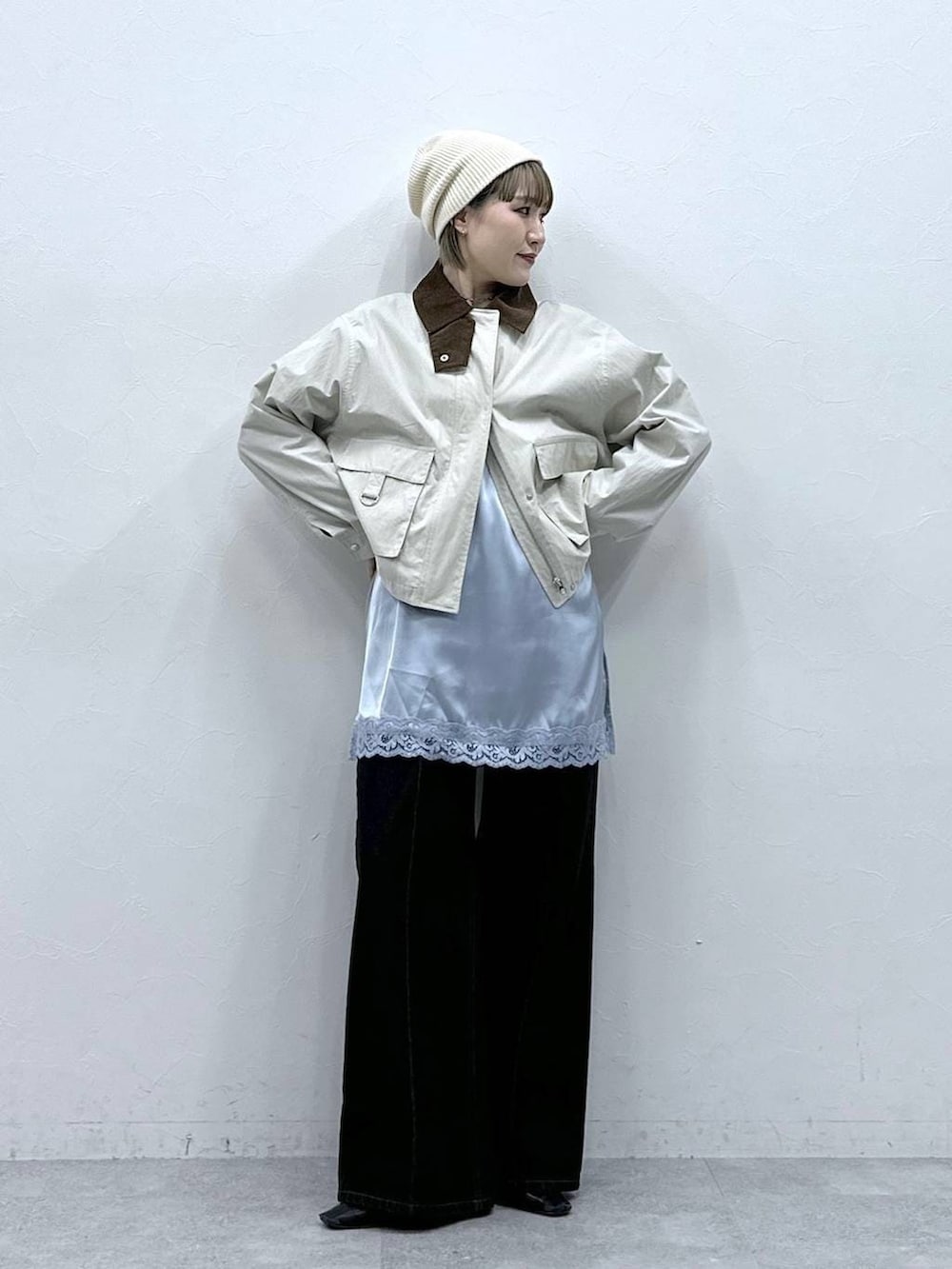 ブラック系のデニムパンツ、ホワイト系のブルゾン、ブルー系のキャミソールを着用したレディースの冬コーディネートの4枚目の写真