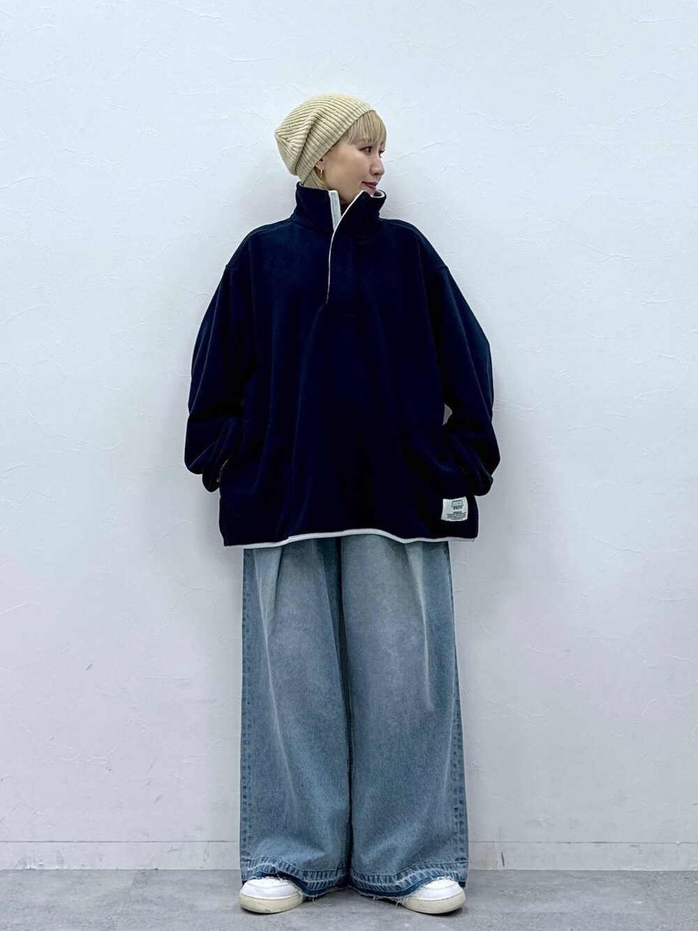 ブルー系のデニムパンツ、ブルー系のスウェット、ベージュ系のハンチング/ベレー帽を着用したレディースの秋コーディネートの2枚目の写真