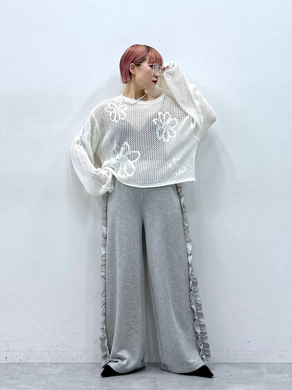 グレー系のスウェットパンツ、ホワイト系のニット/セーター、ホワイト系のネックレスを着用したレディースの春コーディネートの3枚目の写真