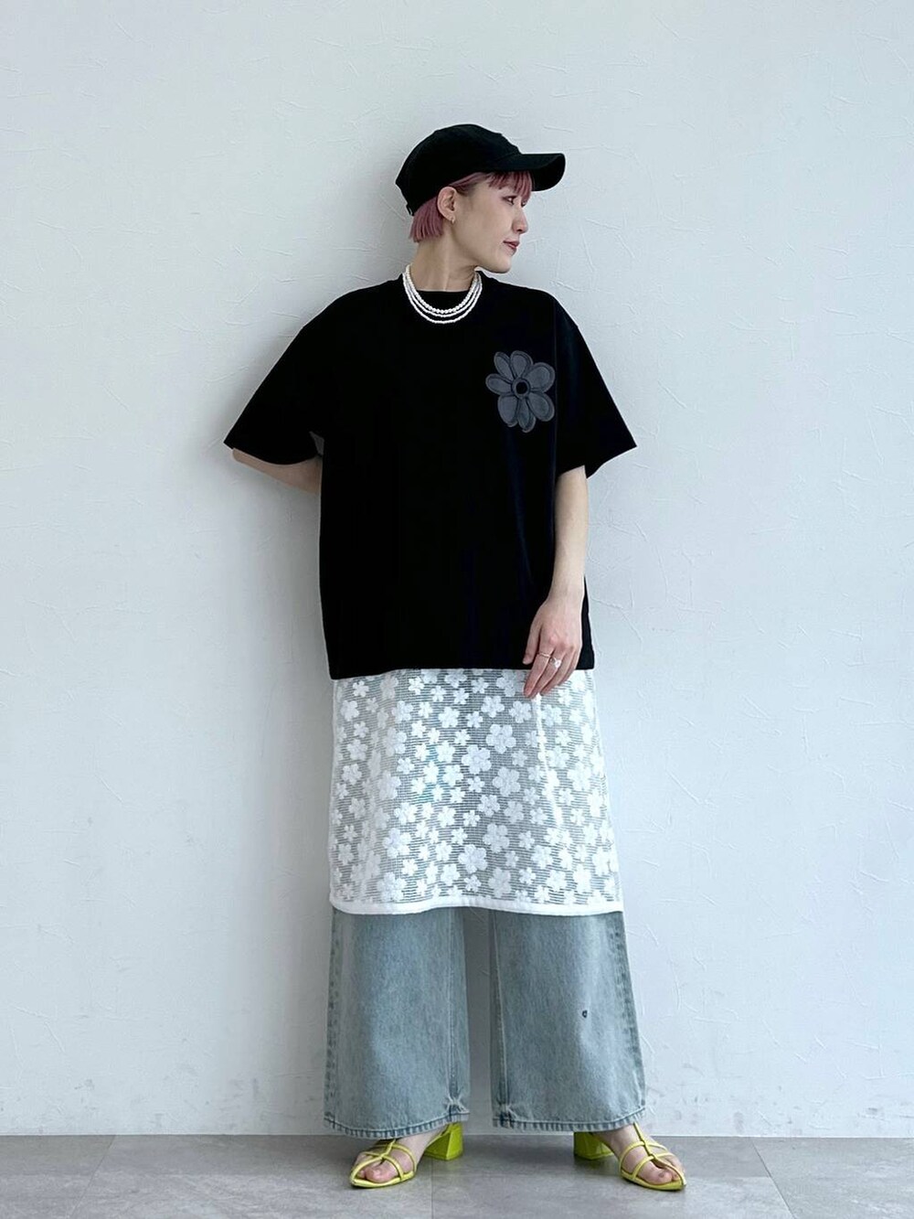 ブルー系のデニムパンツ、ホワイト系のワンピース、ブラック系のTシャツ/カットソーを着用したレディースの春コーディネートの4枚目の写真