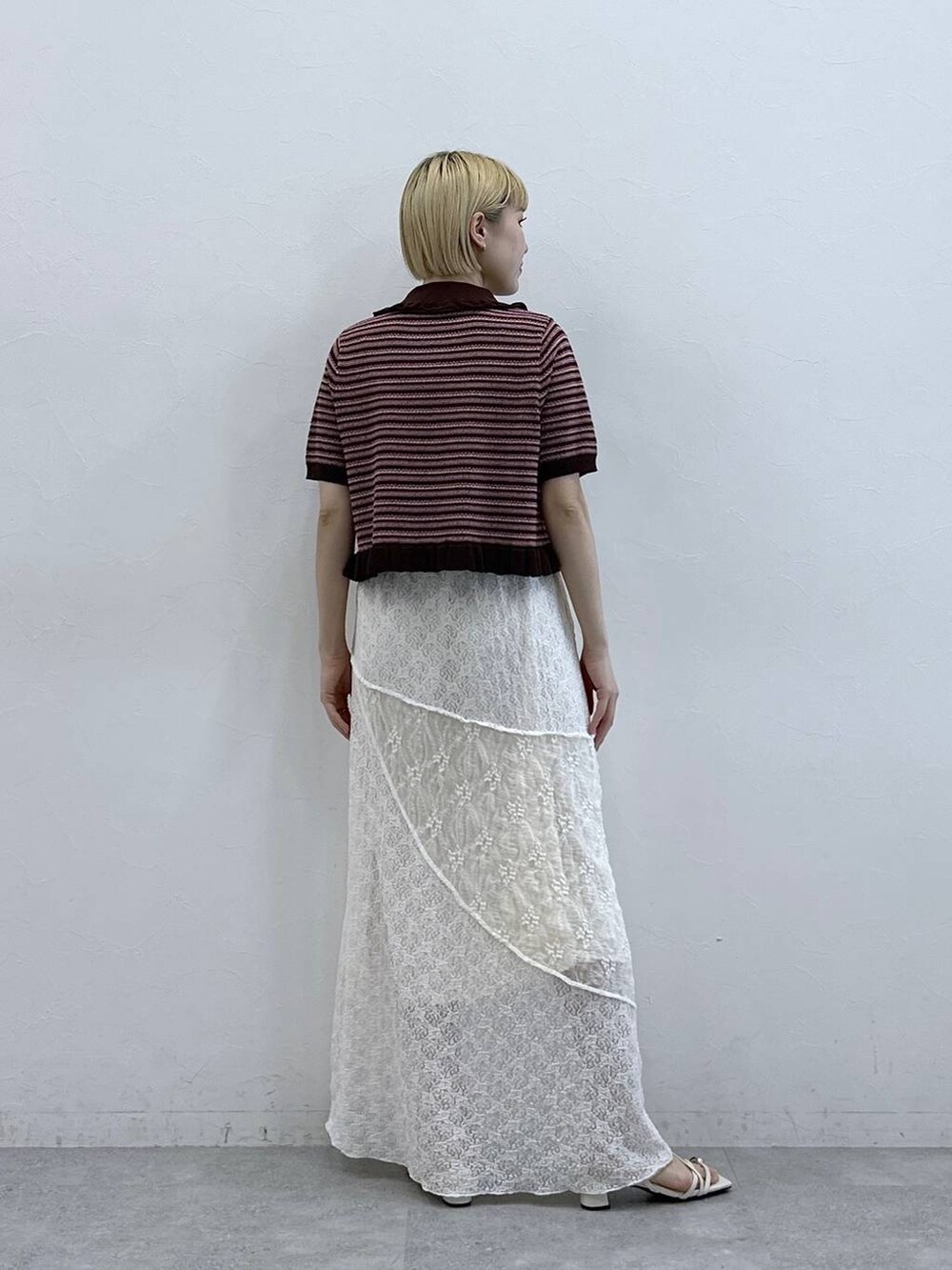 ホワイト系のサンダル、ホワイト系のスカート、ブラウン系のカーディガン/ボレロを着用したレディースの春コーディネートの5枚目の写真