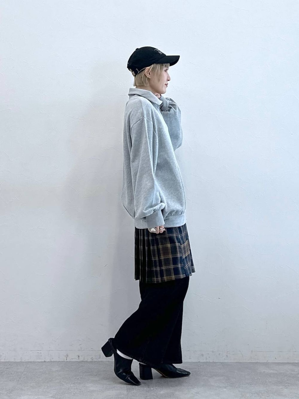 ブラック系のデニムパンツ、グレー系のスウェット、ブラウン系のスカートを着用したレディースの秋コーディネートの4枚目の写真