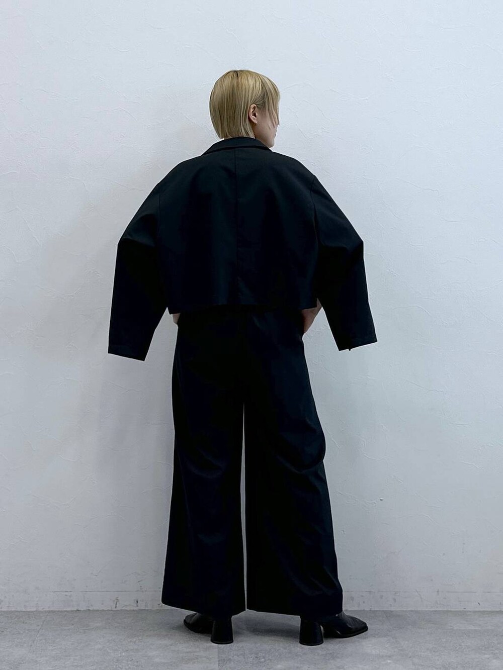 ブラック系のテーラードジャケット、ブラック系のブラジャーを着用したレディースの秋コーディネートの6枚目の写真