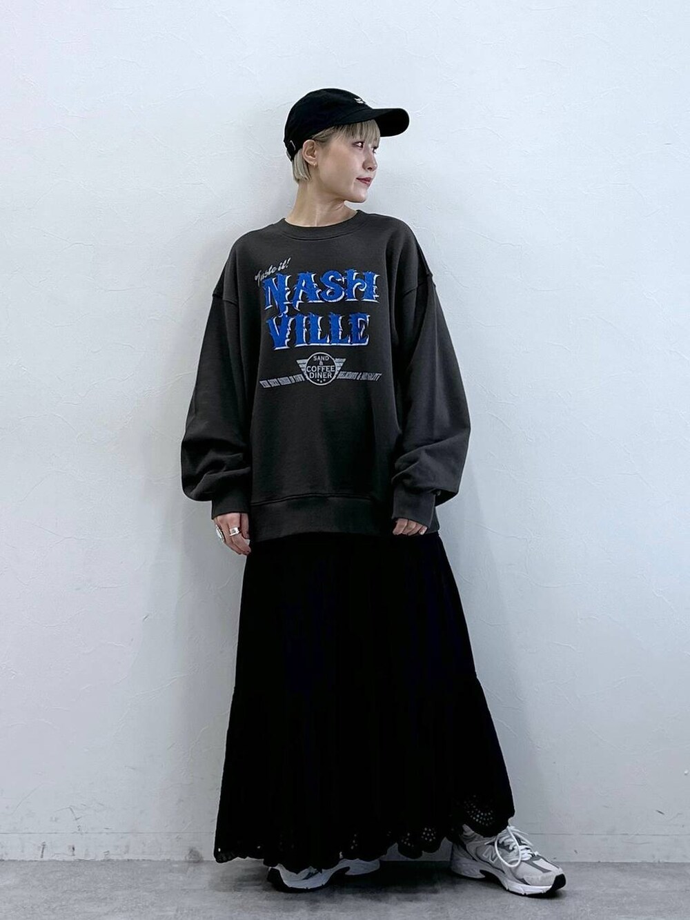 ブラック系のスウェット、ブラック系のスカート、ブラック系のキャップを着用したレディースの冬コーディネートの6枚目の写真