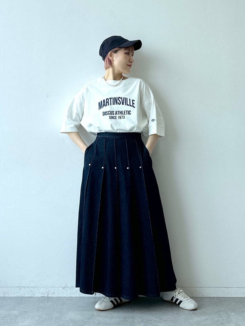 ホワイト系のTシャツ/カットソー、ホワイト系のスニーカー、ブルー系のデニムスカートを着用したレディースの春コーディネートの6枚目の写真