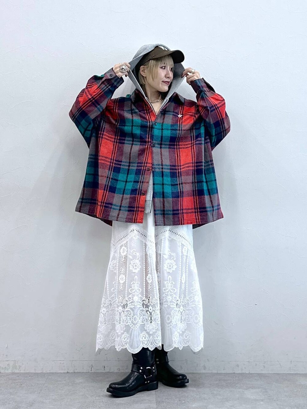 レッド系のシャツ/ブラウス、ブラック系のブーツ、ホワイト系のスカートを着用したレディースの秋コーディネートの2枚目の写真