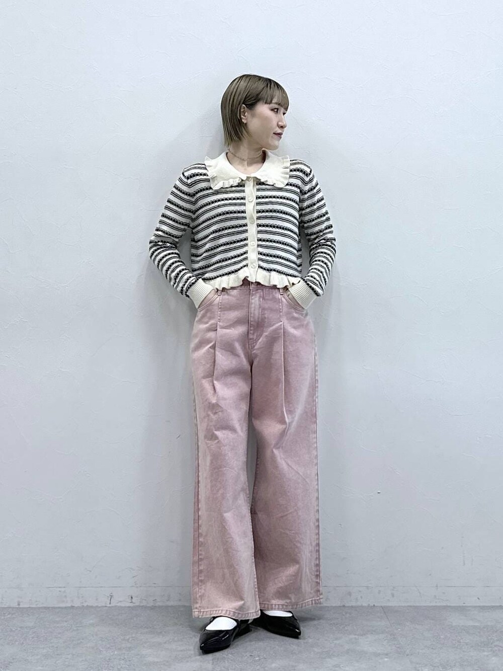 ブラック系のパンプス、ピンク系のデニムパンツ、ホワイト系のカーディガン/ボレロを着用したレディースの冬コーディネートの5枚目の写真