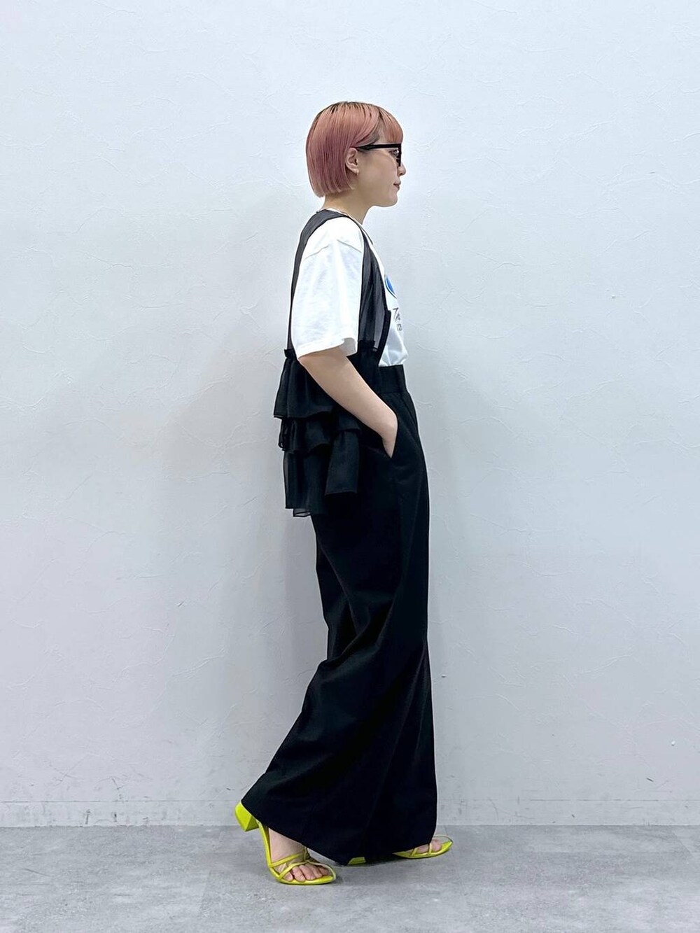 ブラック系のスラックス、ブラック系のベスト、ホワイト系のTシャツ/カットソーを着用したレディースの春コーディネートの4枚目の写真