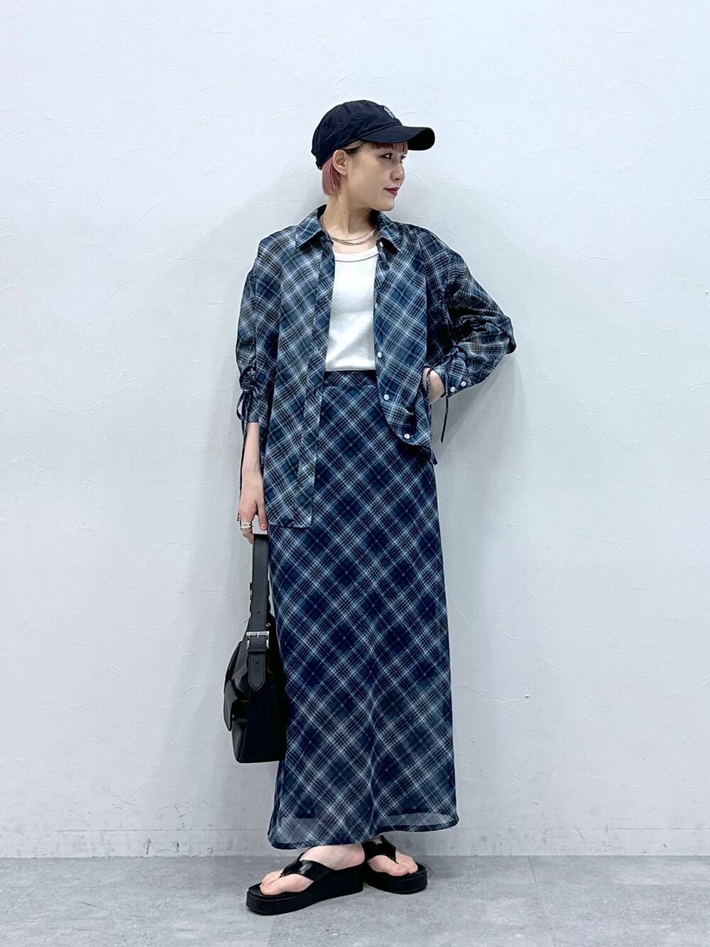 ブルー系のスカート、ホワイト系のタンクトップ、ブルー系のシャツ/ブラウスを着用したレディースの春コーディネートの2枚目の写真