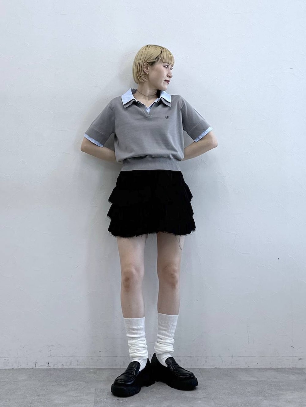 ブラック系のスカート、グレー系のシャツ/ブラウスを着用したレディースの春コーディネートの2枚目の写真