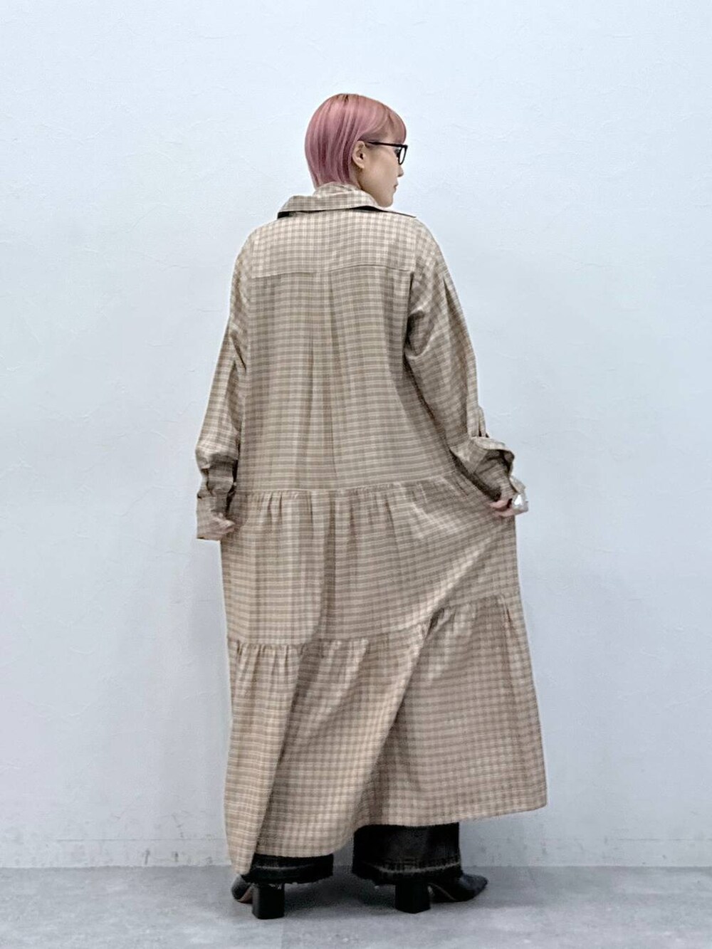 ブラック系のデニムパンツ、ベージュ系のワンピースを着用したレディースの冬コーディネートの6枚目の写真