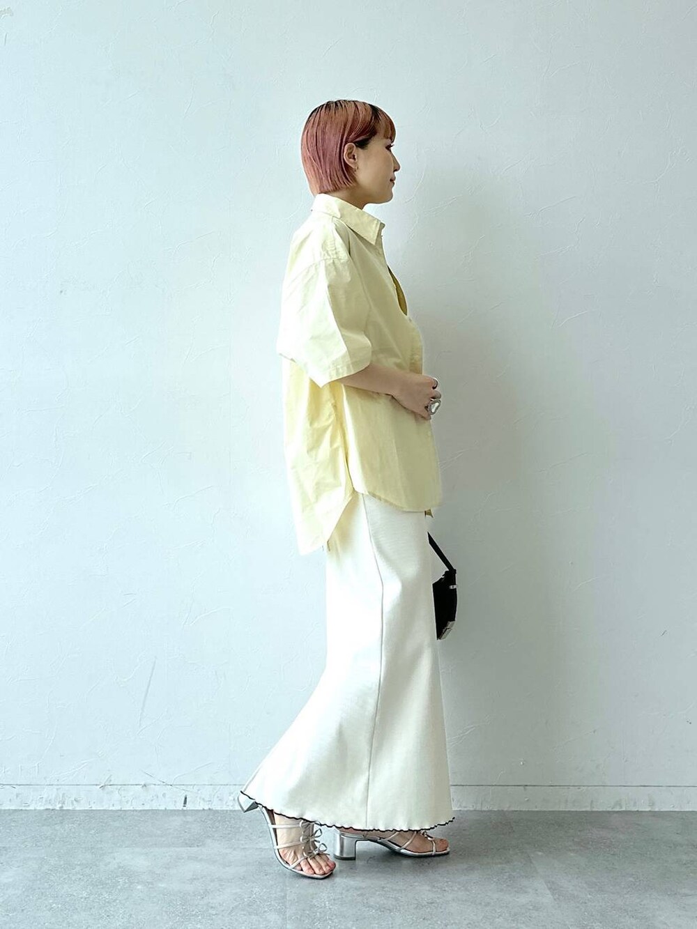ホワイト系のスカート、イエロー系のシャツ/ブラウスを着用したレディースの春コーディネートの4枚目の写真
