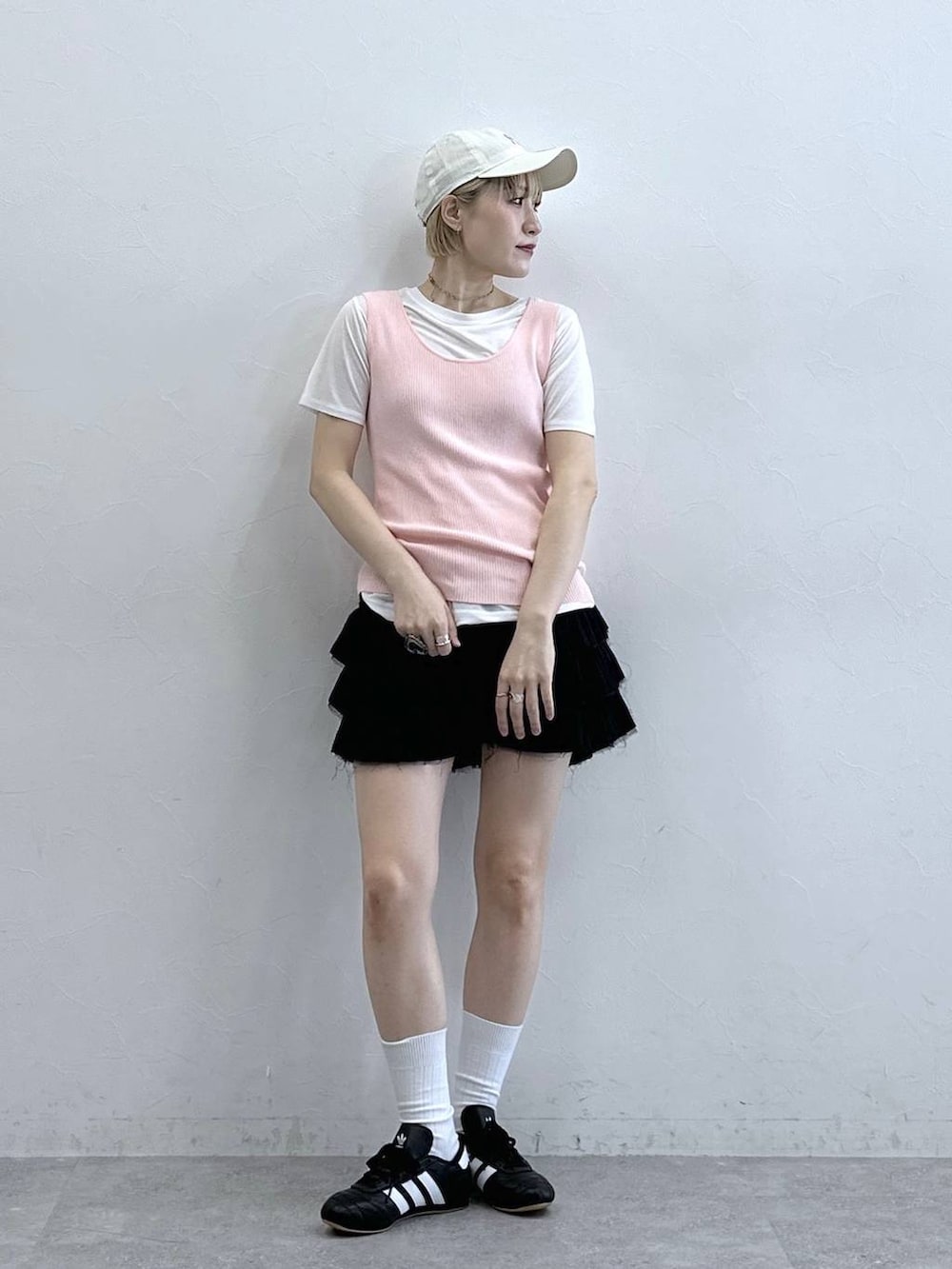 ブラック系のスニーカー、ピンク系のタンクトップ、ホワイト系のTシャツ/カットソーを着用したレディースの春コーディネートの2枚目の写真
