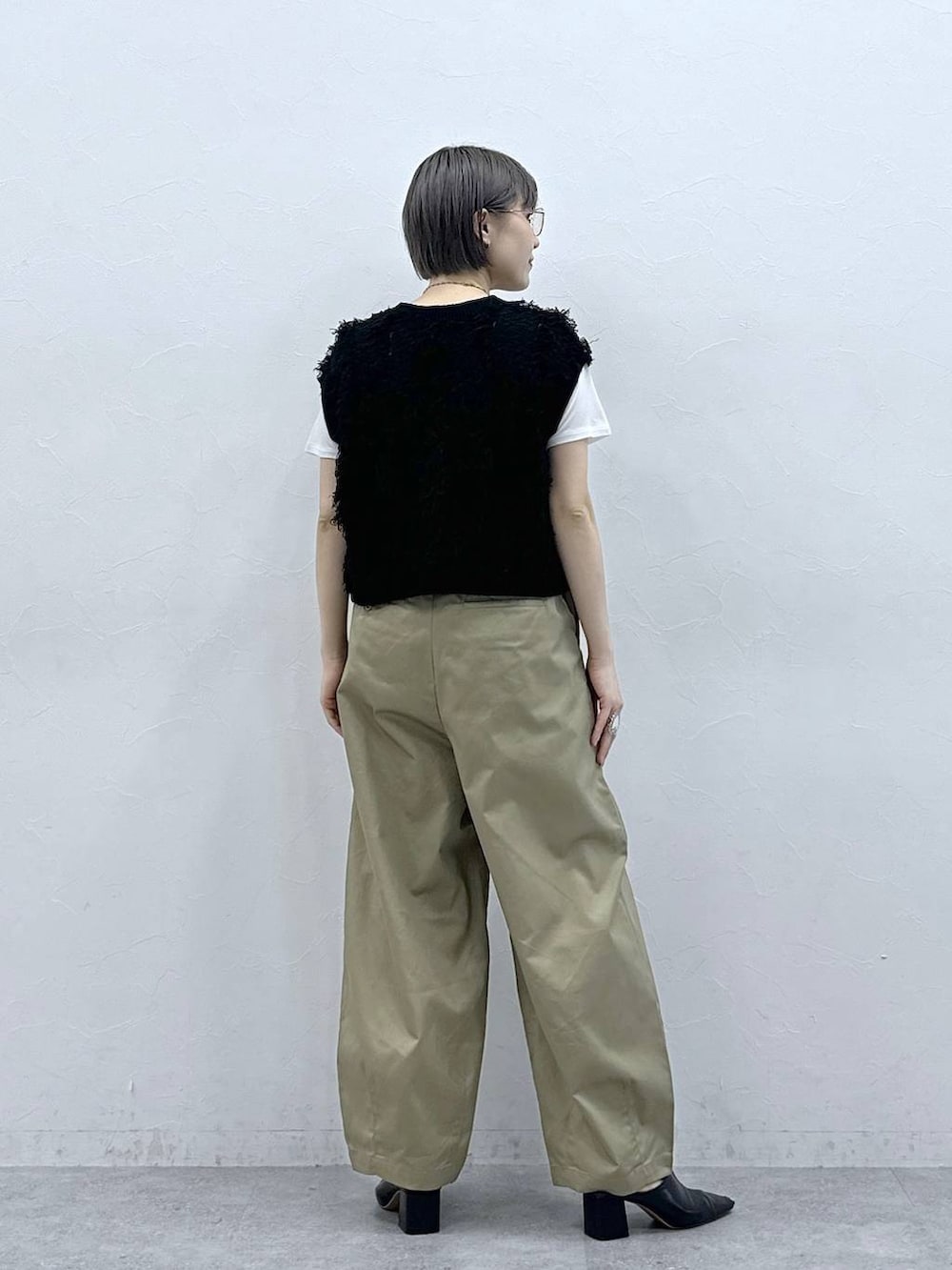 ベージュ系のチノパンツ、ホワイト系のTシャツ/カットソー、ブラック系のベストを着用したレディースの春コーディネートの6枚目の写真