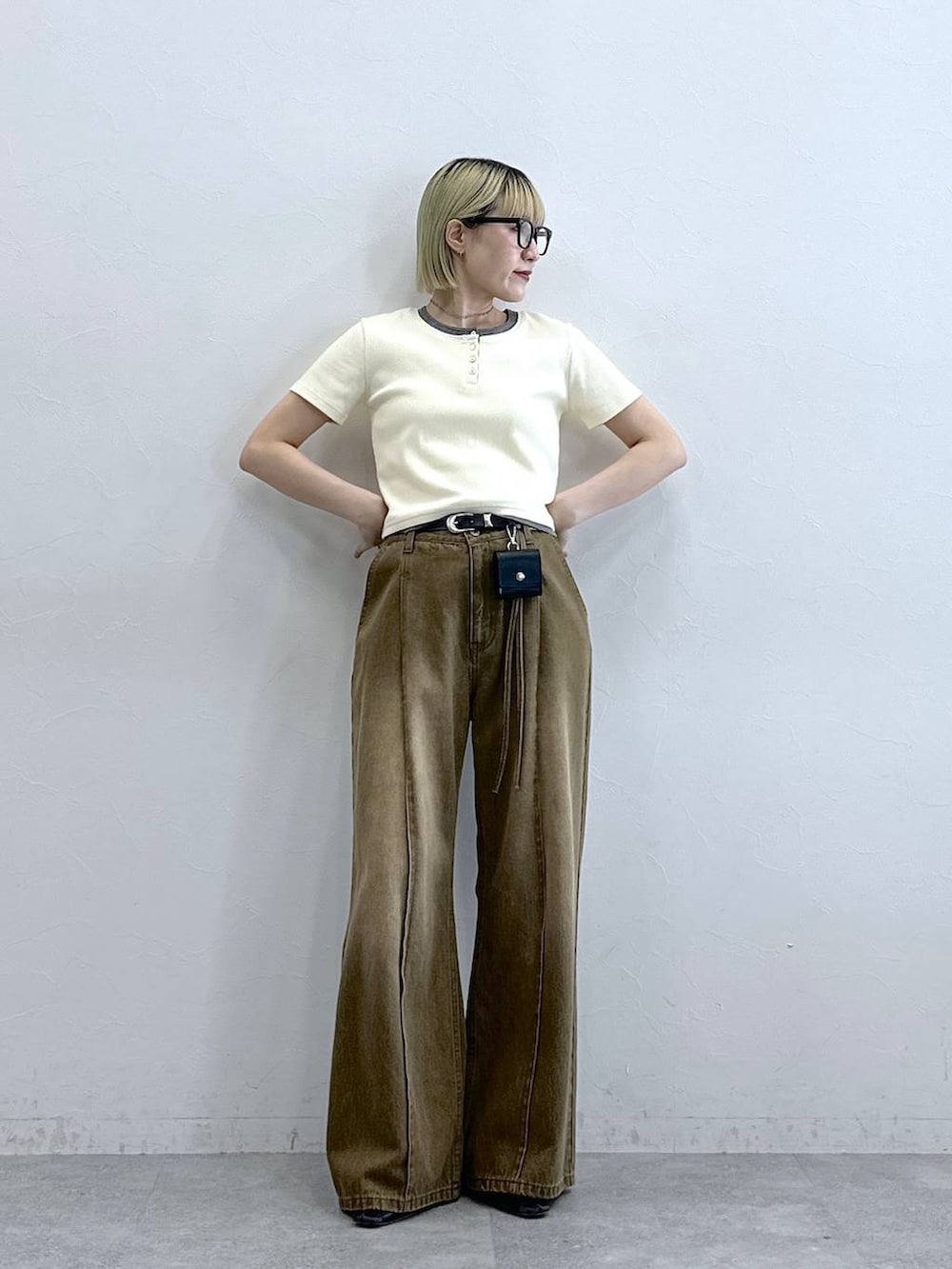 ブラウン系のデニムパンツ、ホワイト系のTシャツ/カットソー、ブラック系のベルトを着用したレディースの夏コーディネートの3枚目の写真