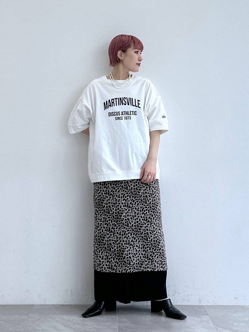 ホワイト系のTシャツ/カットソー、ブラック系のスラックス、ベージュ系のスカートを着用したレディースの春コーディネートの3枚目の写真