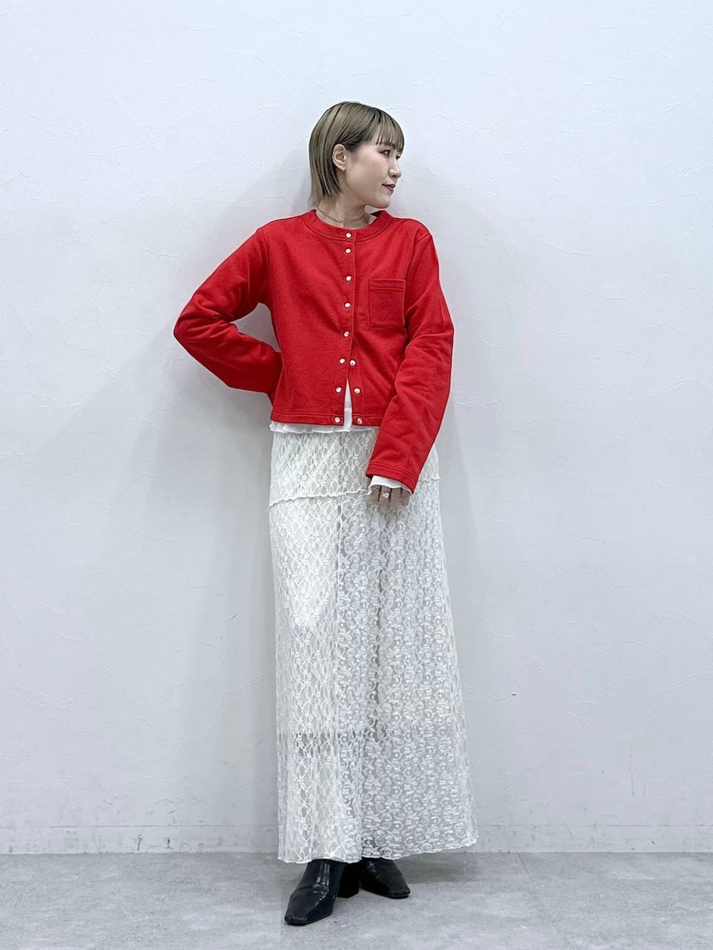 レッド系のカーディガン/ボレロ、ホワイト系のTシャツ/カットソー、ホワイト系のスカートを着用したレディースの冬コーディネートの3枚目の写真