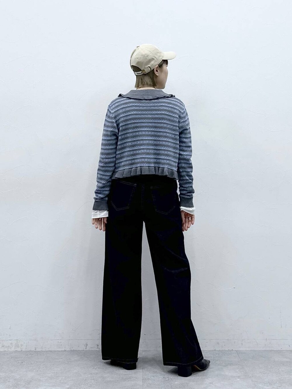 ブラック系のデニムパンツ、ホワイト系のTシャツ/カットソー、グレー系のカーディガン/ボレロを着用したレディースの冬コーディネートの5枚目の写真