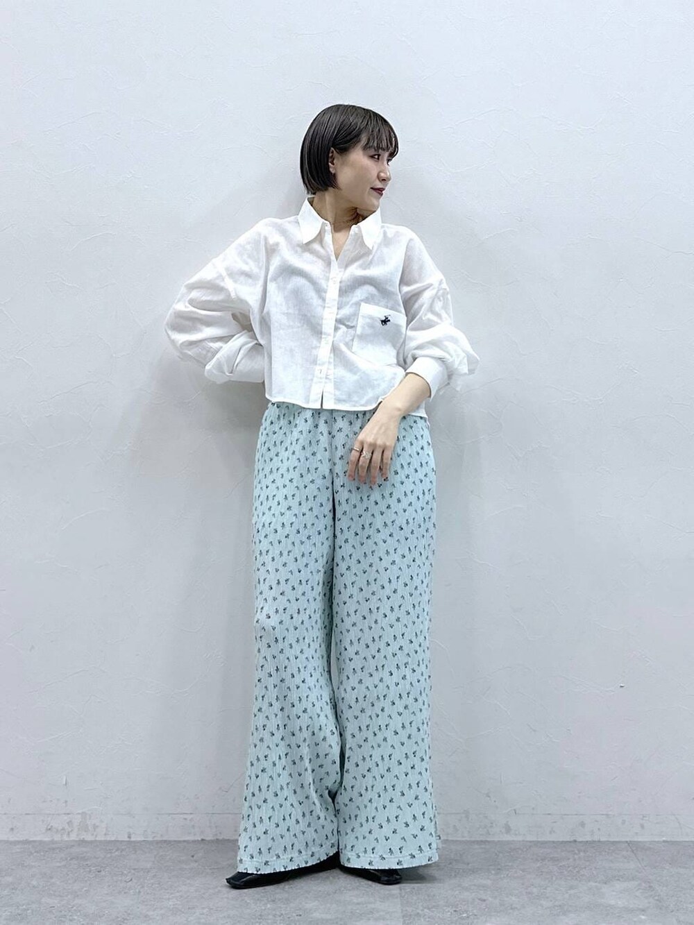 ホワイト系のシャツ/ブラウス、ブルー系のスラックスを着用したレディースの春コーディネートの3枚目の写真