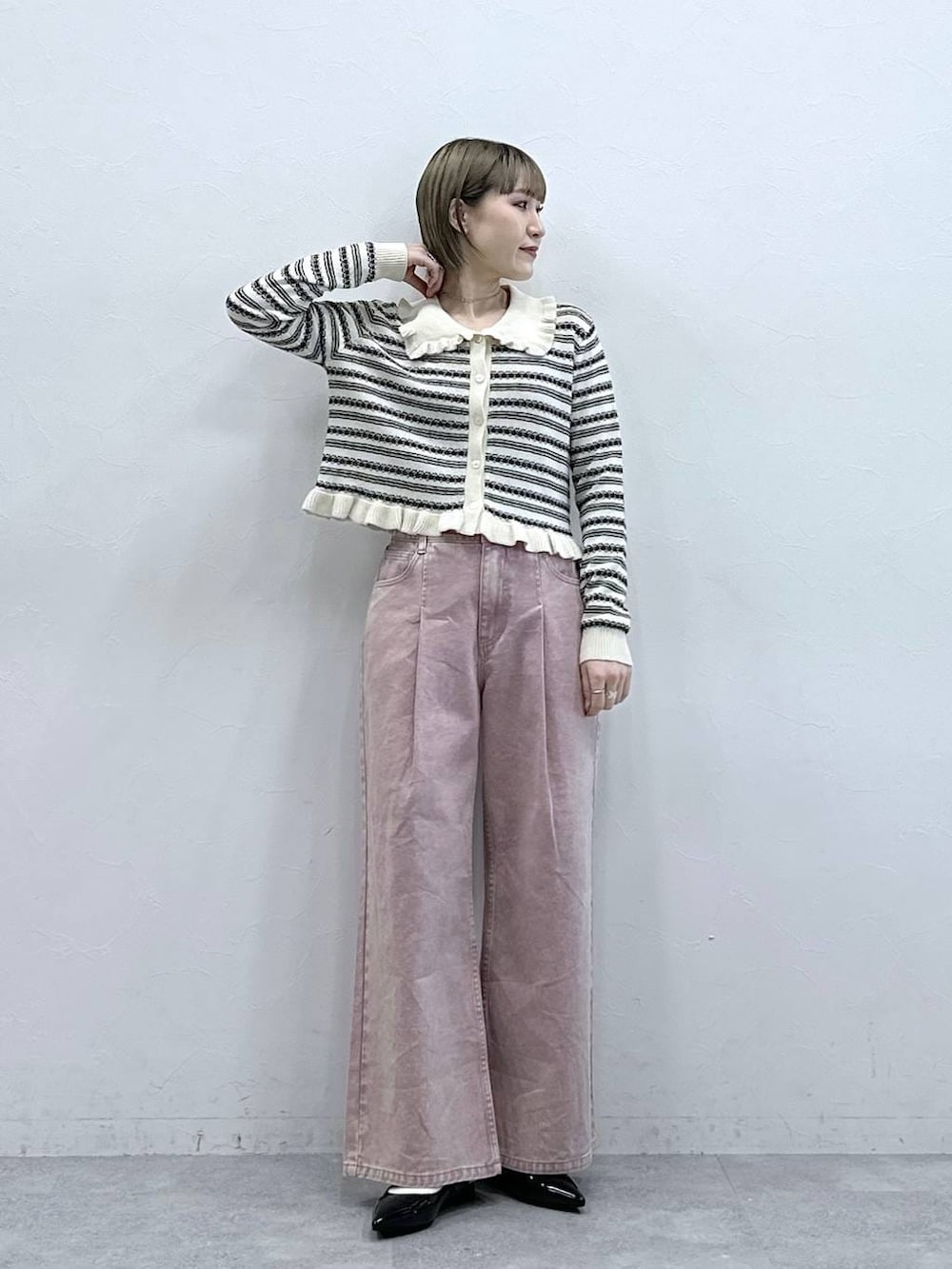 ブラック系のパンプス、ピンク系のデニムパンツ、ホワイト系のカーディガン/ボレロを着用したレディースの冬コーディネートの2枚目の写真