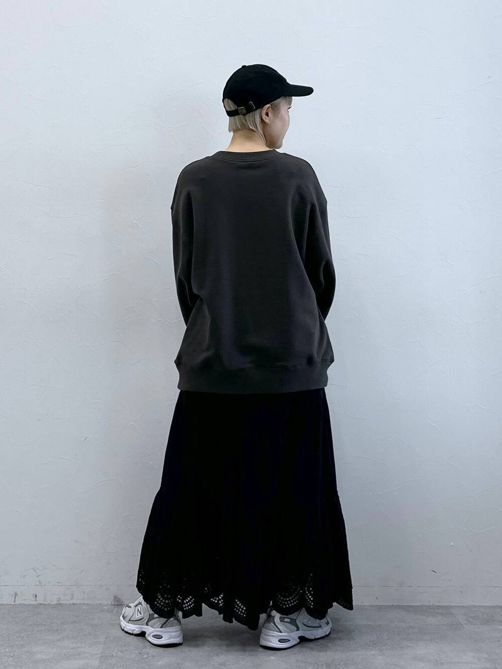 ブラック系のスウェット、ブラック系のスカート、ブラック系のキャップを着用したレディースの冬コーディネートの5枚目の写真