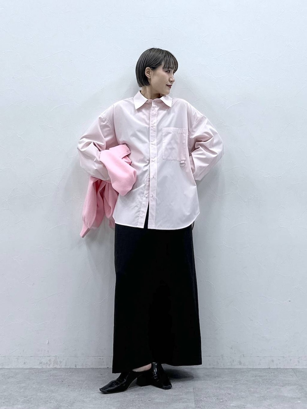 ピンク系のカーディガン/ボレロ、ブラック系のスカート、ピンク系のシャツ/ブラウスを着用したレディースの春コーディネートの2枚目の写真