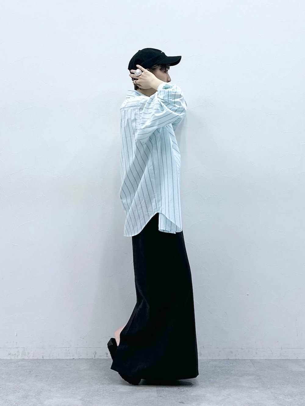 グリーン系のシャツ/ブラウス、ブラック系のモカシン/デッキシューズ、ブラック系のスカートを着用したレディースの春コーディネートの4枚目の写真