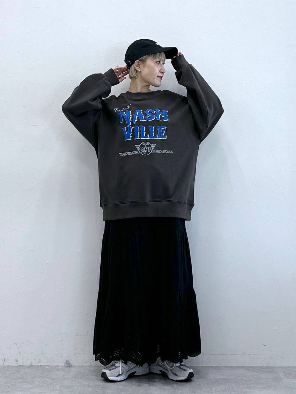 ブラック系のスウェット、ブラック系のスカート、ブラック系のキャップを着用したレディースの冬コーディネートの3枚目の写真