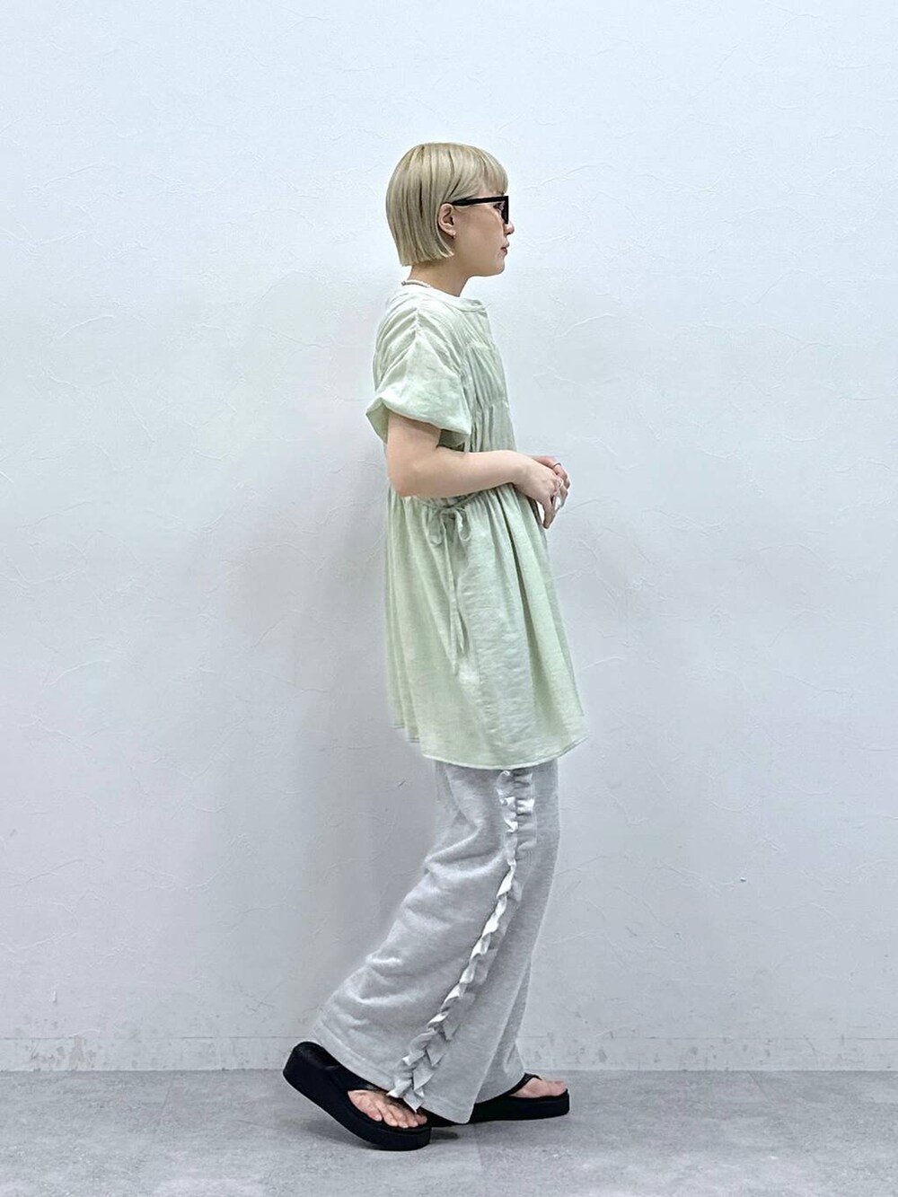 グレー系のスウェットパンツ、グリーン系のシャツ/ブラウス、ブラック系のサンダルを着用したレディースの夏コーディネートの6枚目の写真