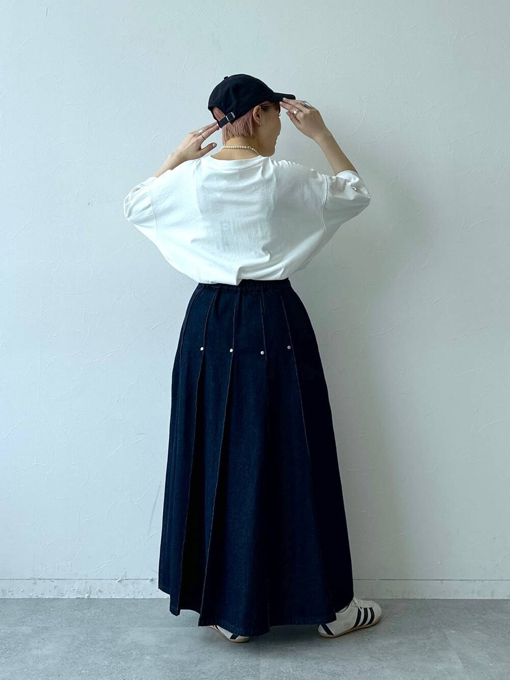 ホワイト系のTシャツ/カットソー、ホワイト系のスニーカー、ブルー系のデニムスカートを着用したレディースの春コーディネートの8枚目の写真