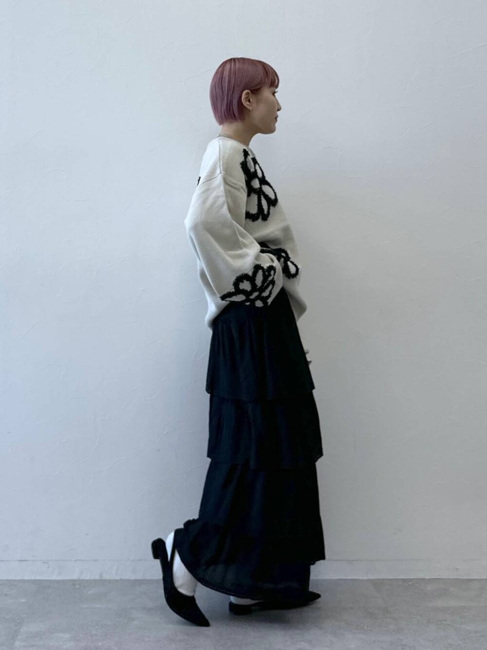 ブラック系のスカート、ホワイト系のニット/セーターを着用したレディースの冬コーディネートの4枚目の写真