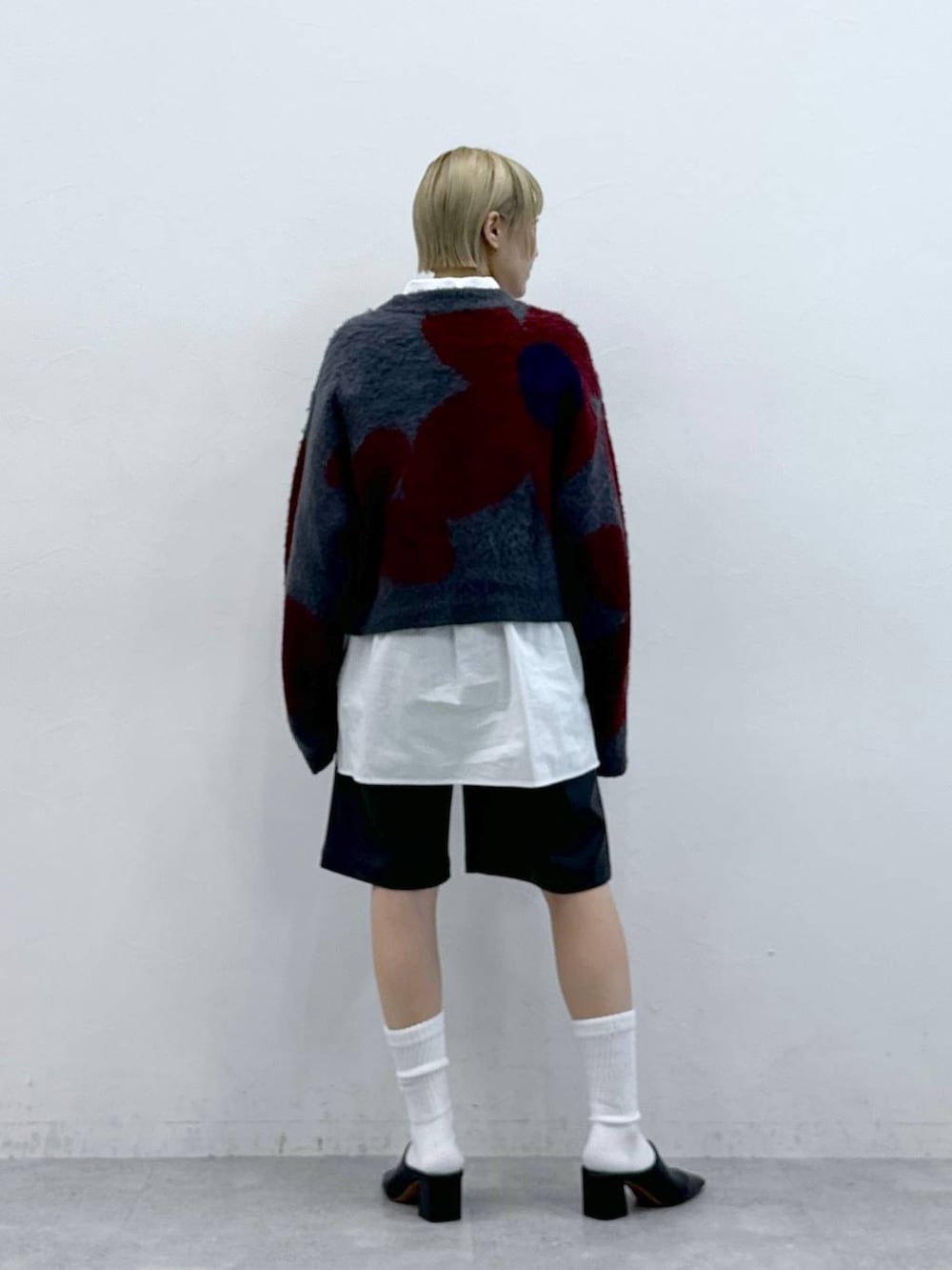 グレー系のニット/セーター、ホワイト系のシャツ/ブラウス、ブラック系のスラックスを着用したレディースの秋コーディネートの5枚目の写真