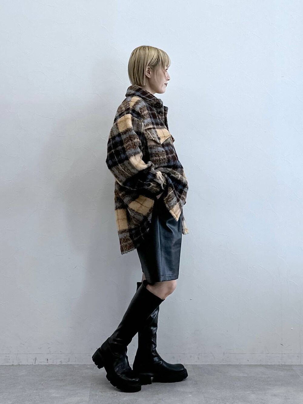 ブラック系のブーツ、ブラック系のスラックス、ブラウン系のブルゾンを着用したレディースの秋コーディネートの4枚目の写真