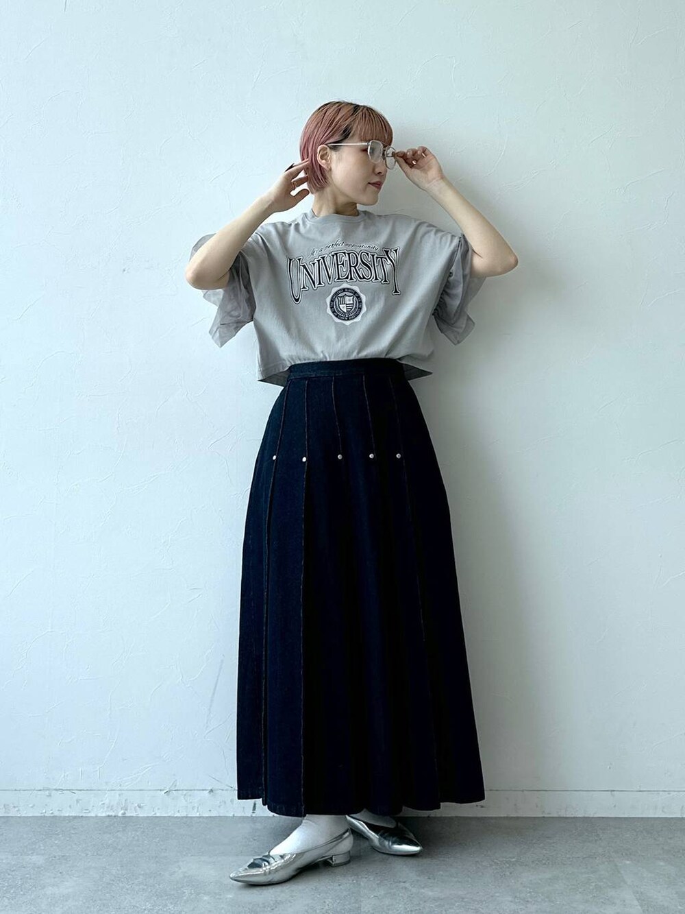 ブルー系のデニムスカート、グレー系のTシャツ/カットソー、ブラック系のメガネを着用したレディースの春コーディネートの4枚目の写真