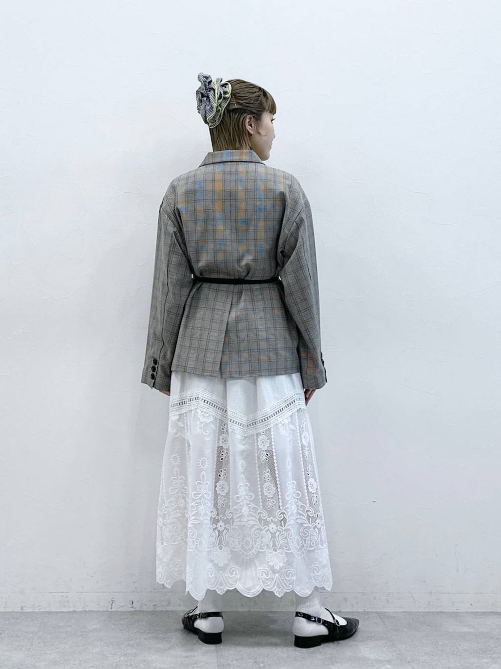 ホワイト系のスカート、ブラック系のパンプス、ベージュ系のテーラードジャケットを着用したレディースの冬コーディネートの5枚目の写真