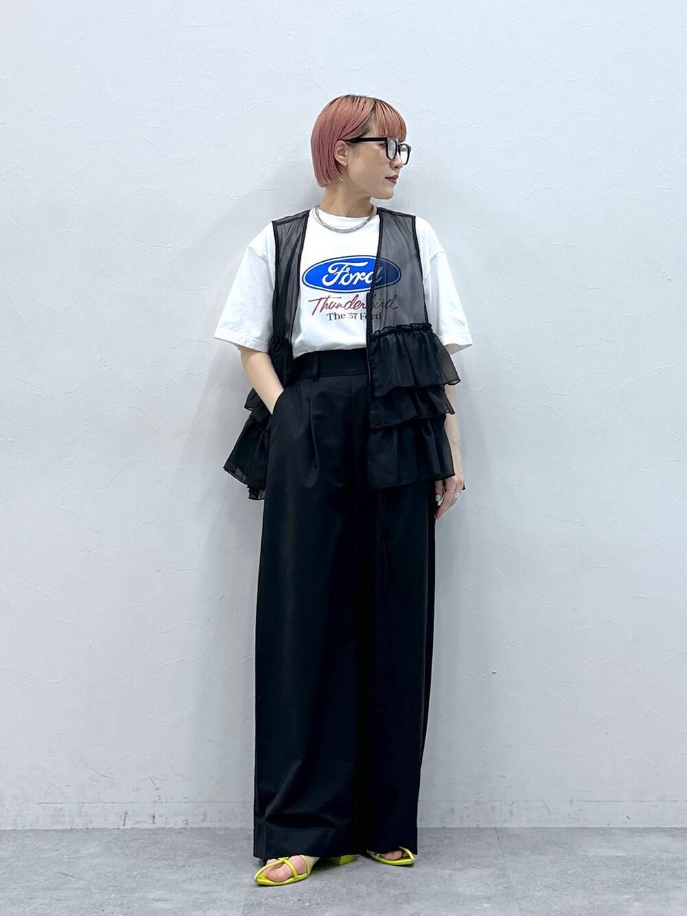 ブラック系のスラックス、ブラック系のベスト、ホワイト系のTシャツ/カットソーを着用したレディースの春コーディネートの2枚目の写真