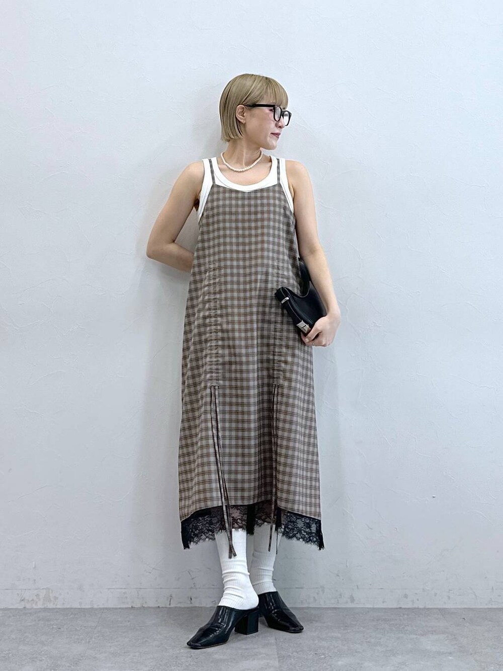 ホワイト系のタンクトップ、グレー系のワンピース、グレー系のメガネを着用したレディースの夏コーディネートの3枚目の写真