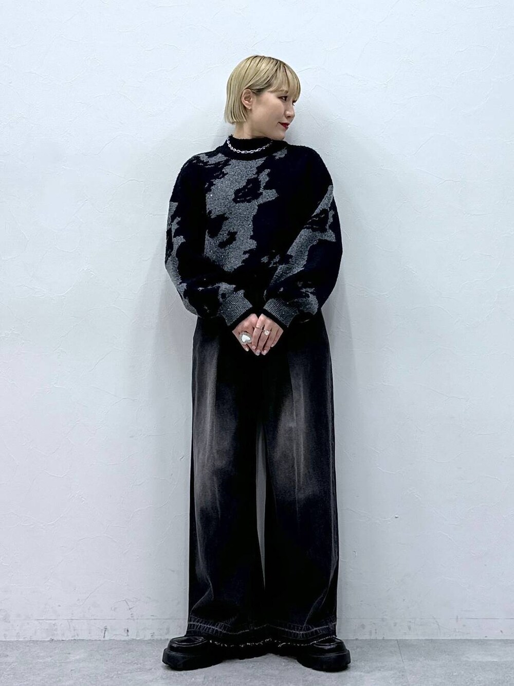 ブラック系のデニムパンツ、ブラック系のニット/セーター、ブラック系のローファーを着用したレディースの冬コーディネートの3枚目の写真