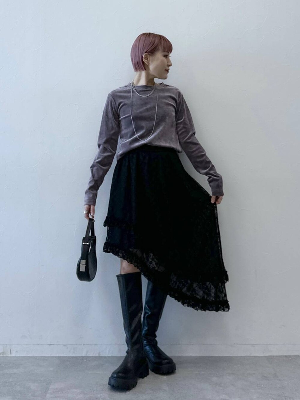 ブラック系のブーツ、パープル系のTシャツ/カットソー、ブラック系のスカートを着用したレディースの冬コーディネートの6枚目の写真