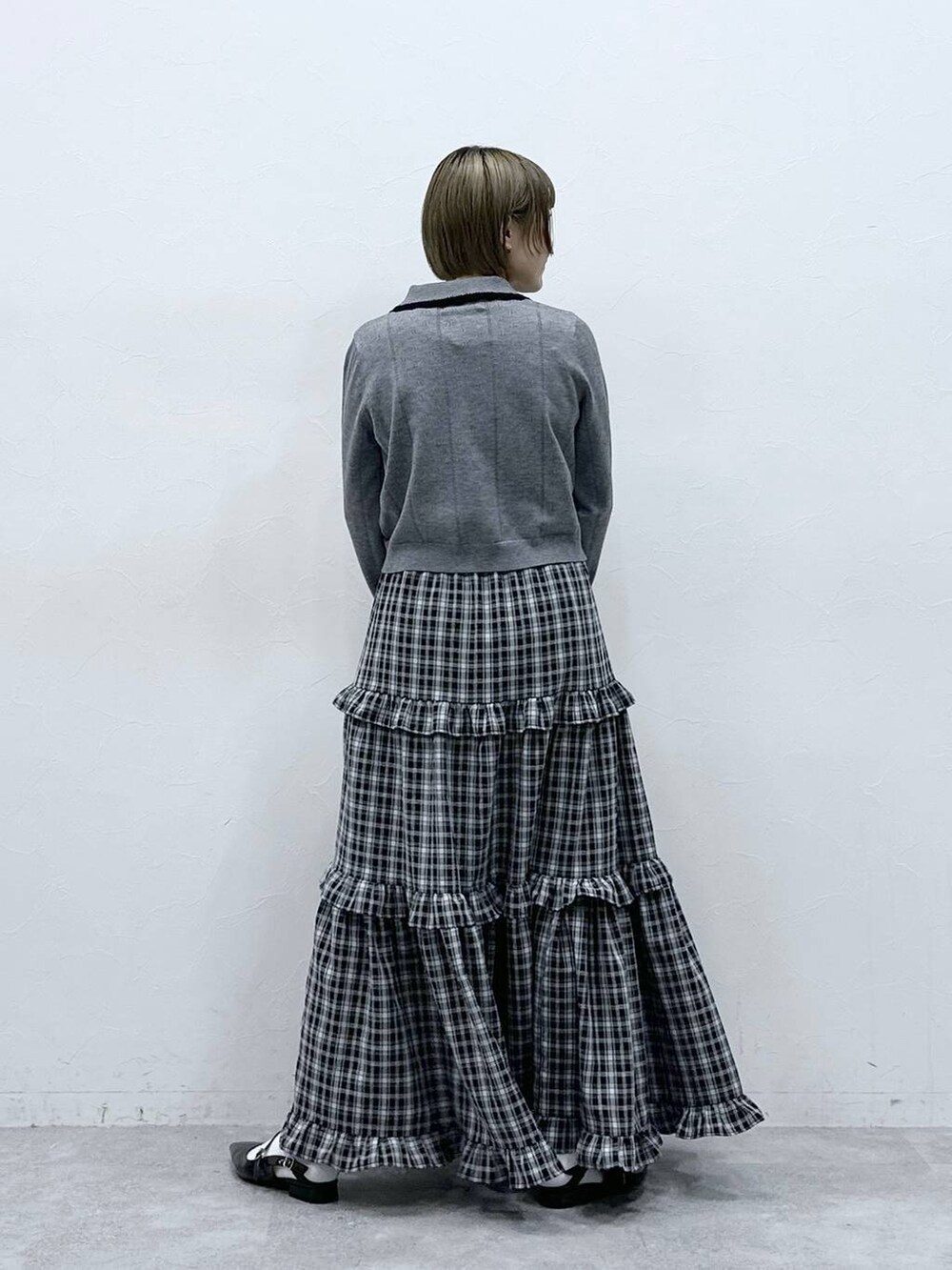 ホワイト系のTシャツ/カットソー、ブラック系のパンプス、グレー系のカーディガン/ボレロを着用したレディースの冬コーディネートの6枚目の写真