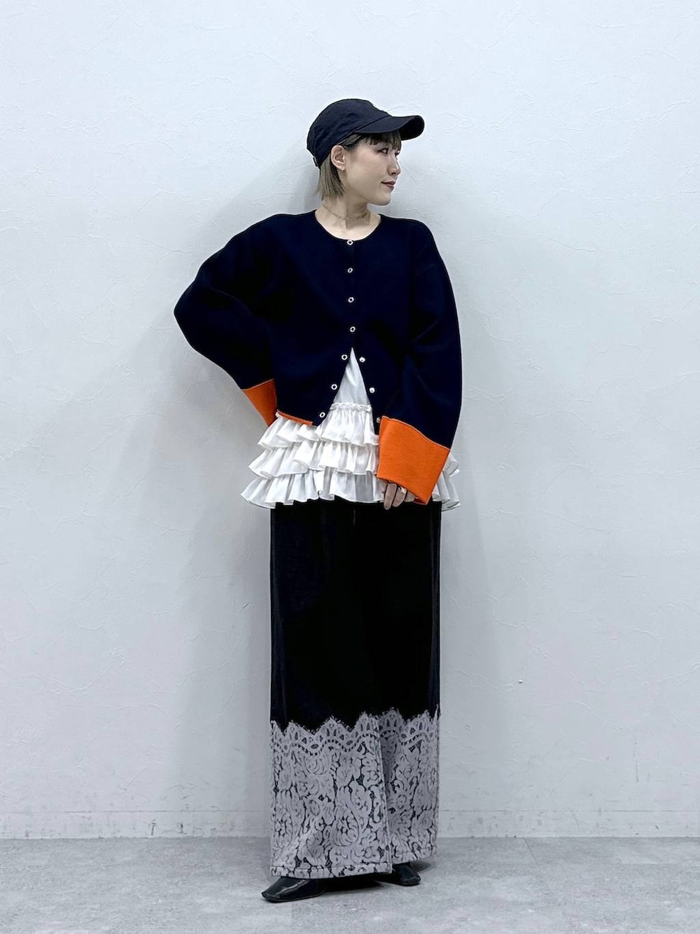 ホワイト系のキャミソール、ブルー系のカーディガン/ボレロ、ブラック系のデニムパンツを着用したレディースの冬コーディネートの3枚目の写真