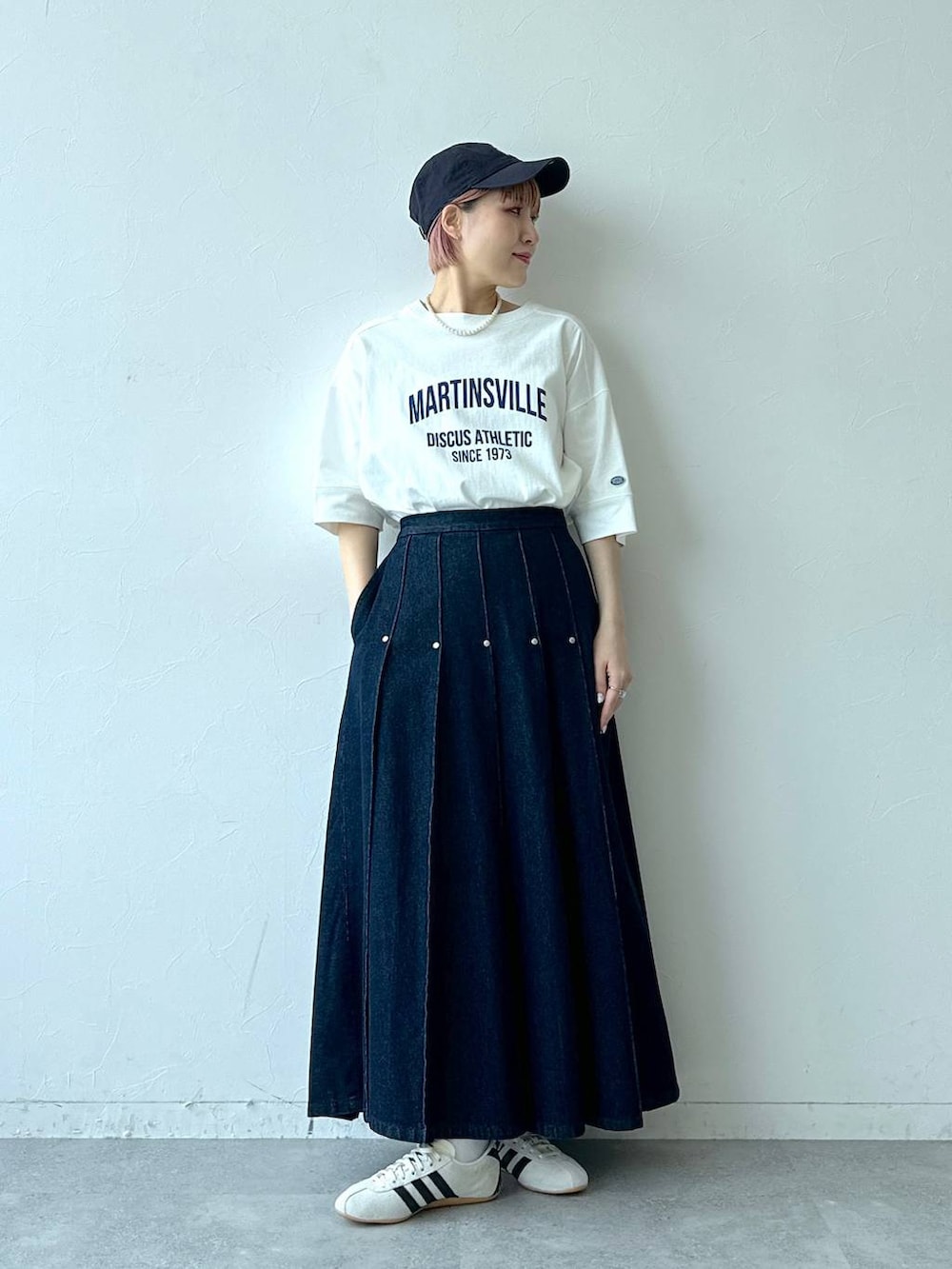 ホワイト系のTシャツ/カットソー、ホワイト系のスニーカー、ブルー系のデニムスカートを着用したレディースの春コーディネートの5枚目の写真