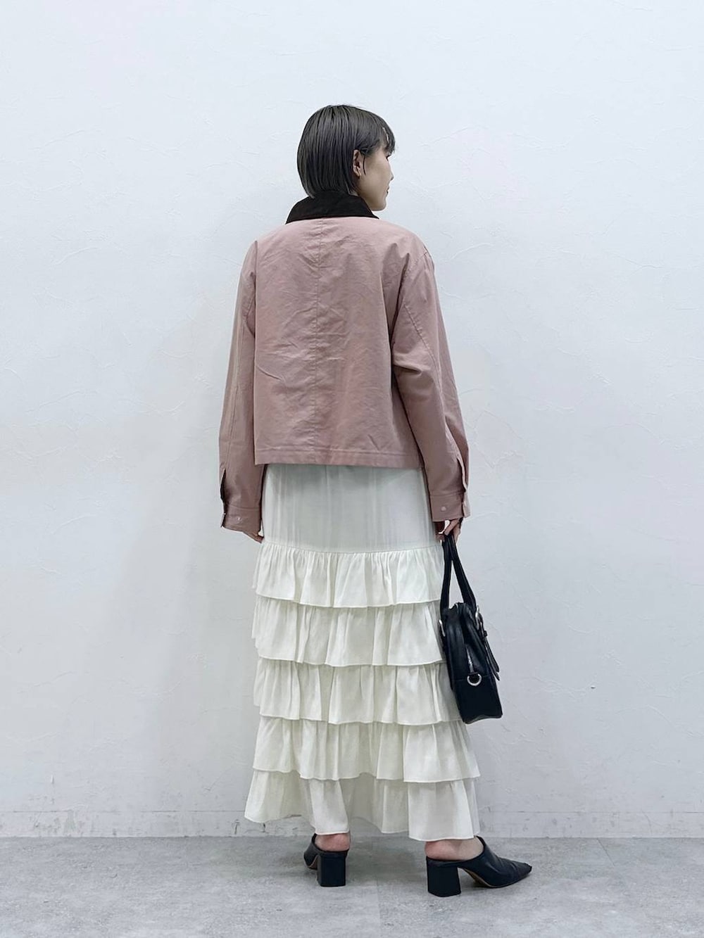 ピンク系のブルゾン、ホワイト系のスカートを着用したレディースの春コーディネートの5枚目の写真