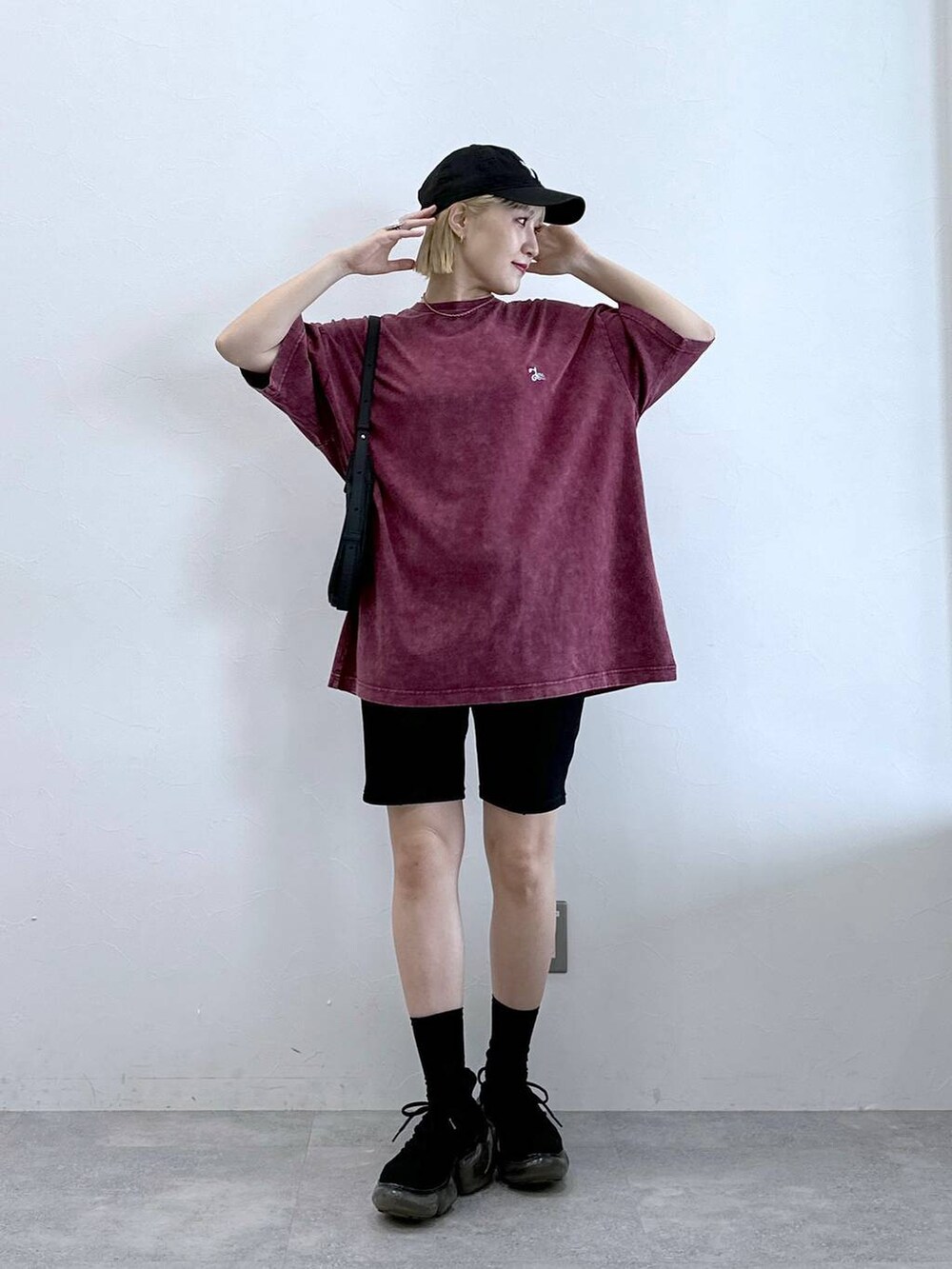 ブラック系のその他パンツ、ブラック系のショルダーバッグ、レッド系のTシャツ/カットソーを着用したレディースの夏コーディネートの2枚目の写真