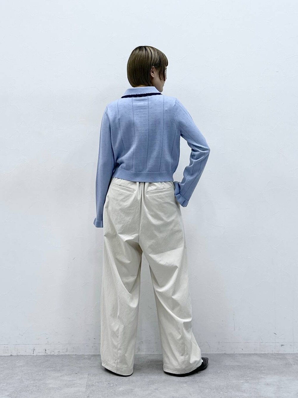 ホワイト系のチノパンツ、ブルー系のカーディガン/ボレロ、ブラック系のパンプスを着用したレディースの冬コーディネートの5枚目の写真