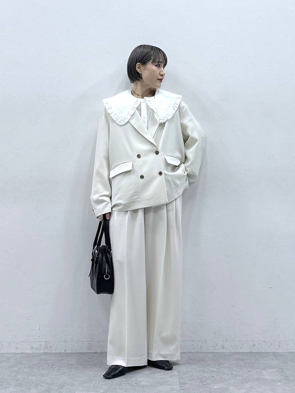 ホワイト系のシャツ/ブラウス、ブラック系のボストンバッグ、ホワイト系のテーラードジャケットを着用したレディースの春コーディネートの3枚目の写真