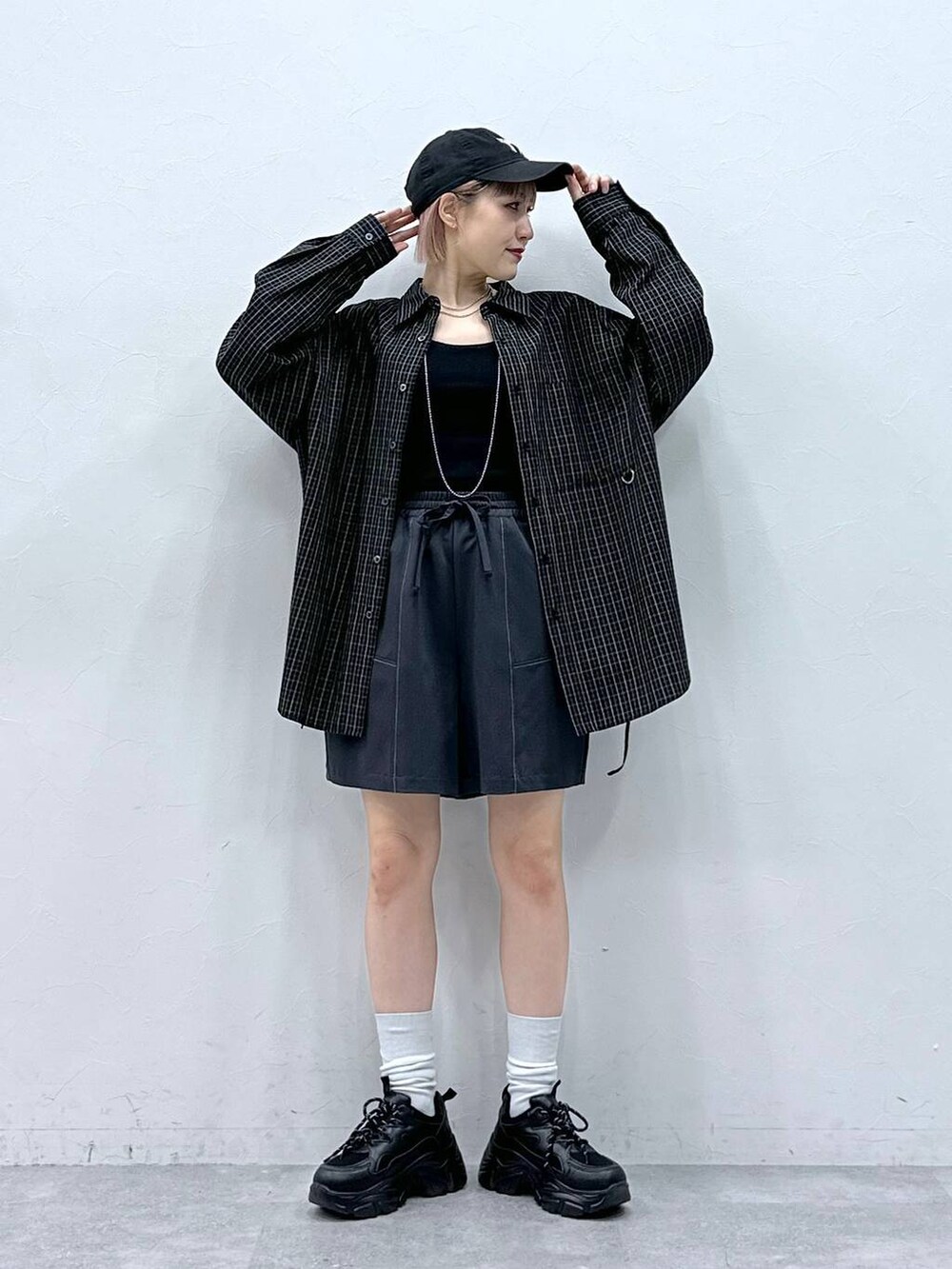 ブラック系のスニーカー、ブルー系のスラックス、ブラック系のシャツ/ブラウスを着用したレディースの春コーディネートの2枚目の写真