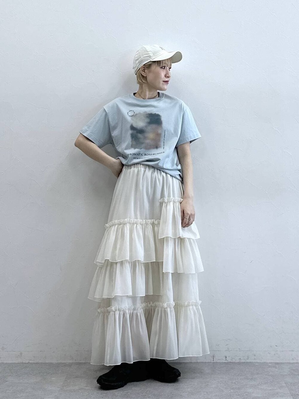 ブルー系のTシャツ/カットソー、ホワイト系のスカート、ホワイト系のキャップを着用したレディースの春コーディネートの2枚目の写真