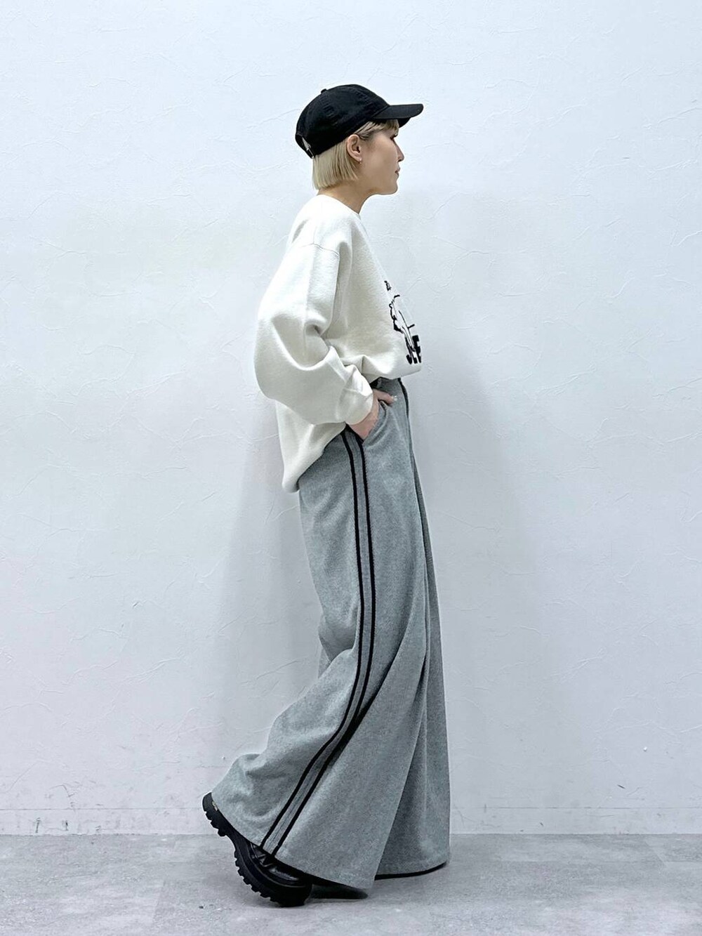 ブラック系のスラックス、ホワイト系のニット/セーターを着用したレディースの冬コーディネートの4枚目の写真