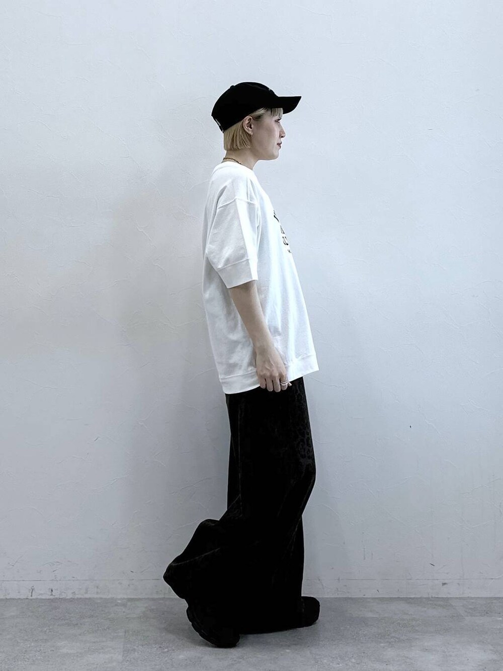 ホワイト系のTシャツ/カットソー、ブラック系のサンダル、ブラウン系のデニムパンツを着用したレディースの春コーディネートの4枚目の写真